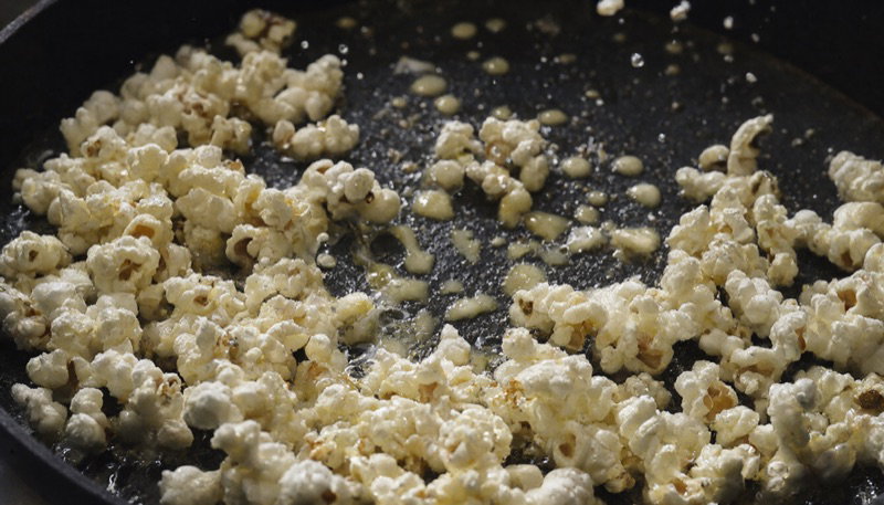 Popcorn bursting in a dark pan